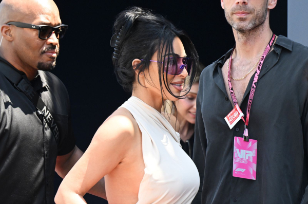 Kim Kardashian wears a oneshoulder dress and a claw clip hairstyle.